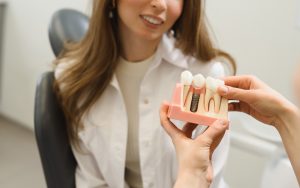a dentist is demonstrating how dental implants work using a model